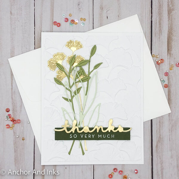 Deeply embossed gingko leaves on a white background with sprigs of gold foil ginkgo leaves and various green foliage adorn a sophisticated thank you card. The Art of The Thank You Card