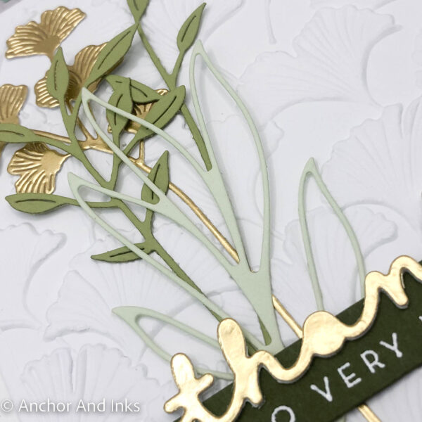 Deeply embossed gingko leaves on a white background with sprigs of gold foil ginkgo leaves and various green foliage adorn a sophisticated thank you card