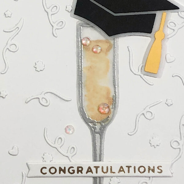 champagne flute and grad cap congratulations up close
